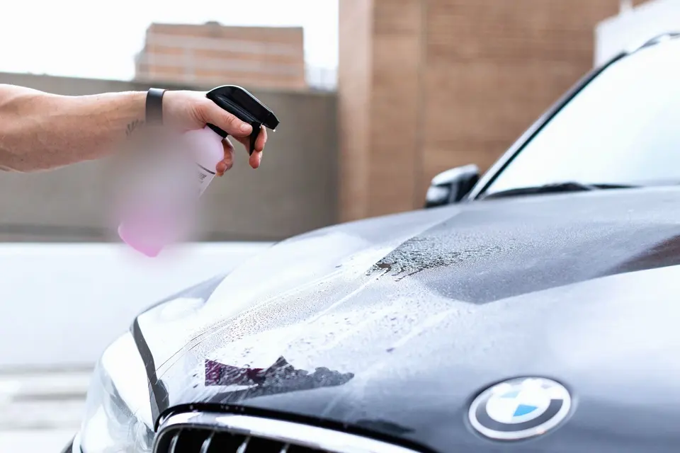 A Person Spraying the Hood of a Car