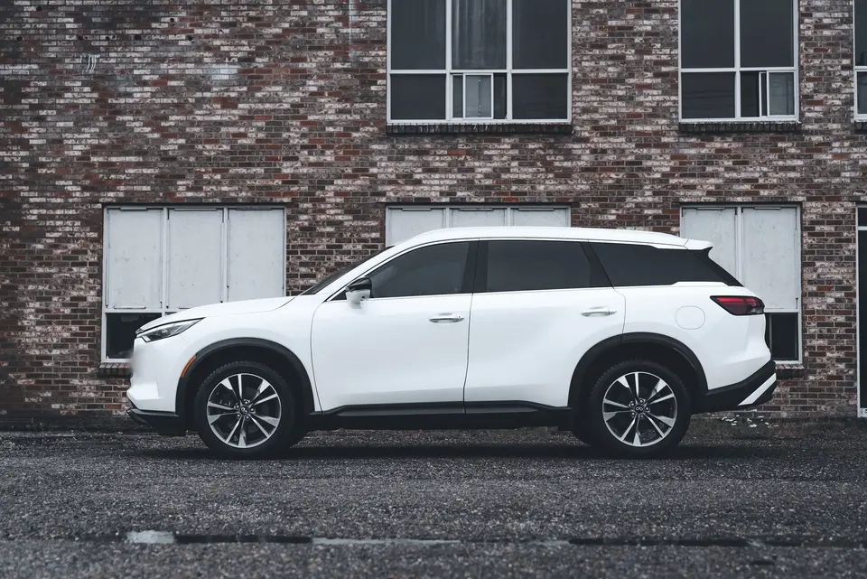 The white 2020 toyota highlander parked in front of a brick wall